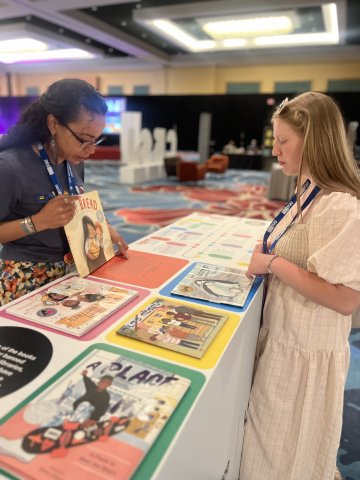 Two CRSJ conference attendees look at the display of banned or challenged books