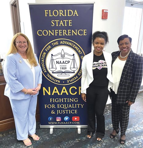 NEA President Becky Pringle stands in front of a banner at a Florida State University event with FEA Vice President Carole Gauronskas and Student-FEA President Alana Rigby