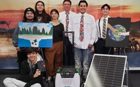 Teacher Jeff Rivero stands with his students and their solar power project