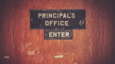 close up of sign on wooden door that says Principal's Office: Enter