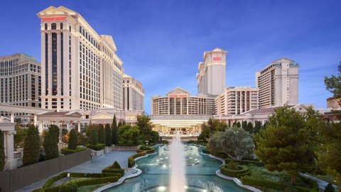 photo of vegas hotel, Caesars palace, with several buildings and a water fountain in front.