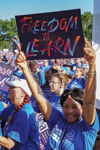 Black female NEA Member holding up a sign that says Freedom to Learn at a rally.
