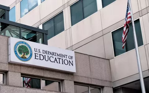 front of the U.S. department of education building with a U.S. flag flying