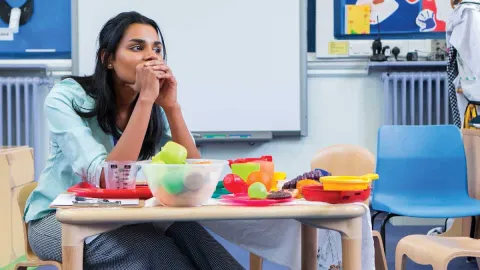 Asian female in deep thought while sitting in her classroom.